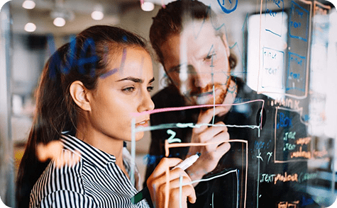 Two people writing on a board